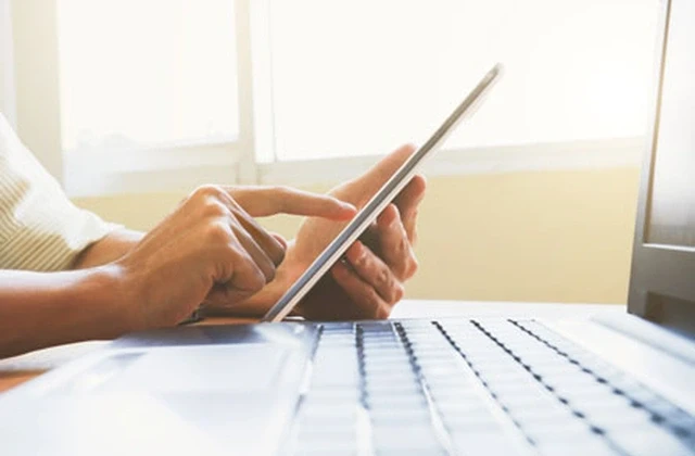 Ein Mann fühlt über ein Tablet ein digitales Formular aus.