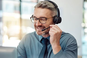 Ein Servicemitarbeiter führt ein freundliches Telefonat mit einem Kunden oder einer Kundin.