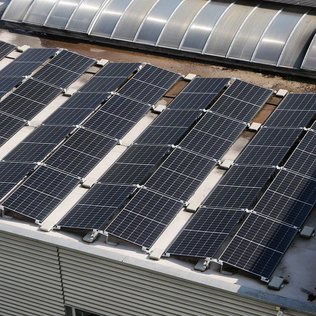Dach eines Gewerbegebäudes mit Solarmodulen, die installiert worden sind, um die Energiekosten zu senken.