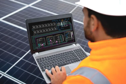Facharbeiter für PV-Montage, der die Solaranlage über einen Computer mit der PV-Software überprüft.